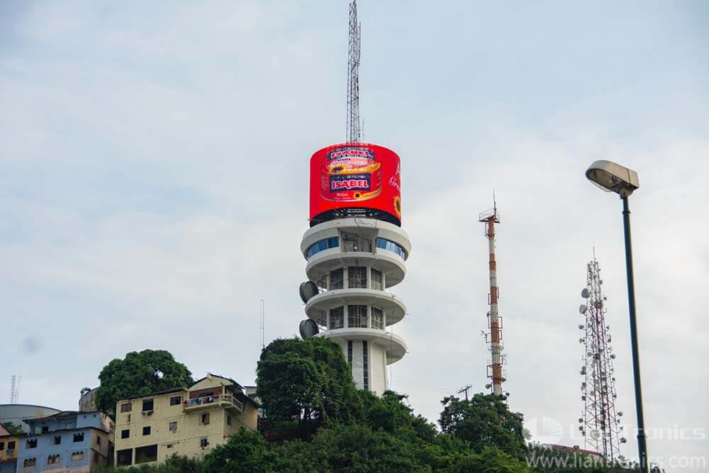 Cartel led cilíndrico gigante en la parte superior de una torre de televisión, Ecuador
